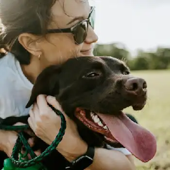 woman wearing sunglasses with chocolate labrador